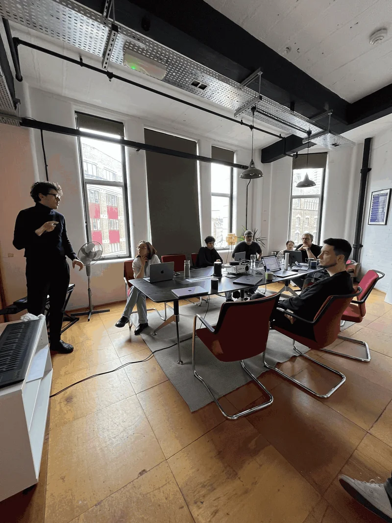 The AudioStack team in a working session around a long table of laptops